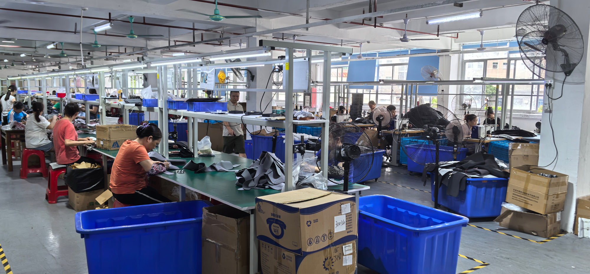 HailiCare factory workers assembling heated shoulder brace massagers with quality control checks